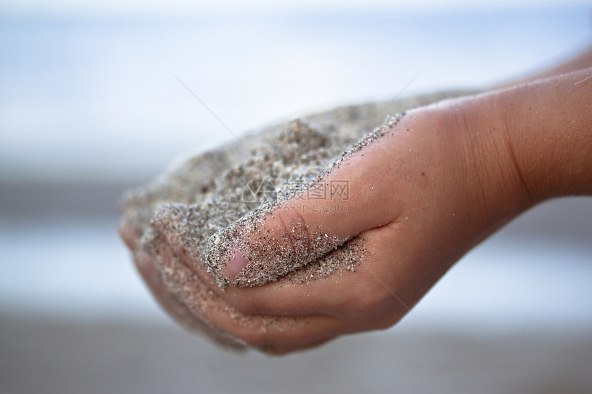 儿童手里握着沙子运动假期蓝色手指男生地平线皮肤天堂天空气候图片