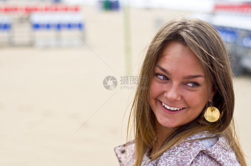 女人在海滩上微笑白色衣服披风眼睛耳环女性露天头发图片