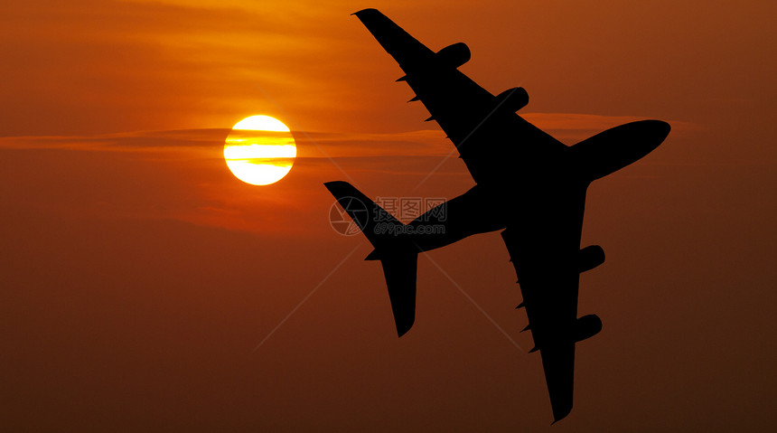 红日落上空的航空班机图片