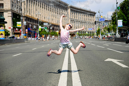 跳跃的小女孩女孩城市运动微笑街道游客房子乐趣女性快乐背景图片