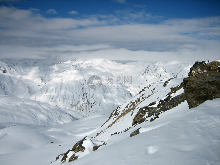 冬季山旅行蓝色天际太阳岩石全景地形场景荒野顶峰图片