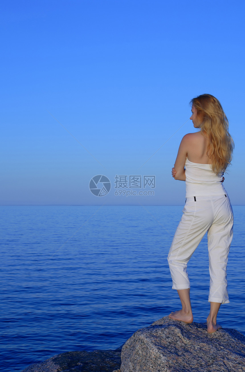 平静的年轻女人看着大海图片