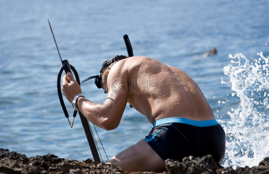 不同潜水员猎人男人支撑食物海岸打猎潜水蓝色岩石图片
