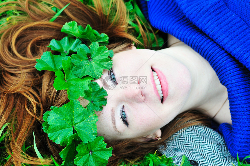 红发红发女孩 用树叶的王冠太阳草地阳光保健蓝色植物自由乐趣卫生头发图片