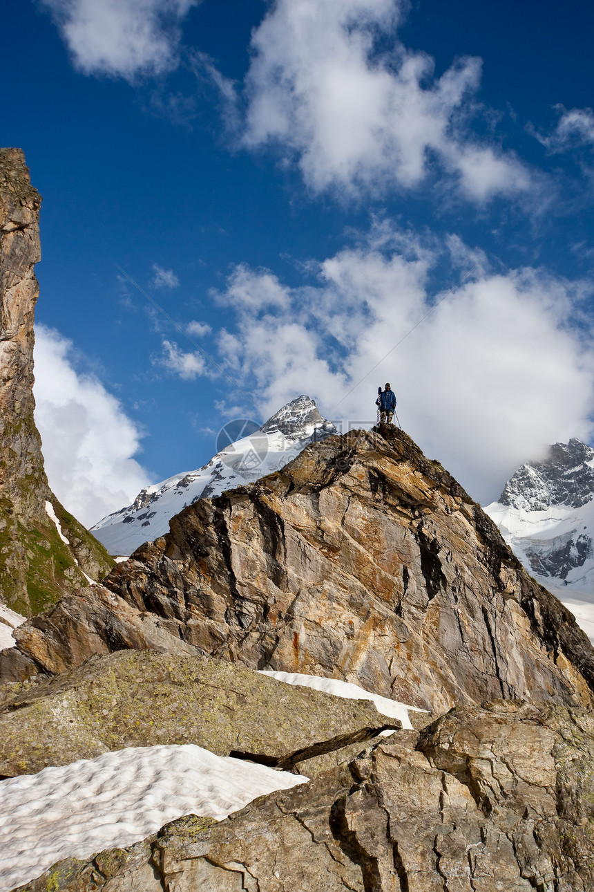 山顶上的小数字蓝色自然假期天空男人荒野解决方案旅游岩石冰川图片