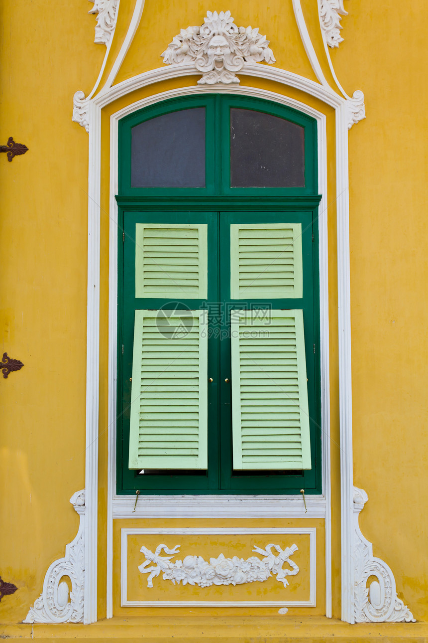 黄色墙上的绿窗被特写控制板木头财产窗格窗户建筑框架水泥房子树木图片