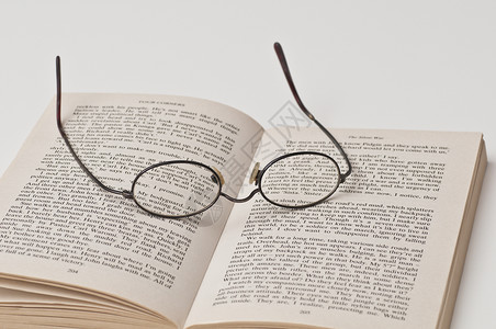 在开放书本上带有黑色四边框的眼镜反射阅读眼睛镜片阴影近视乐器验光师玻璃技术背景图片