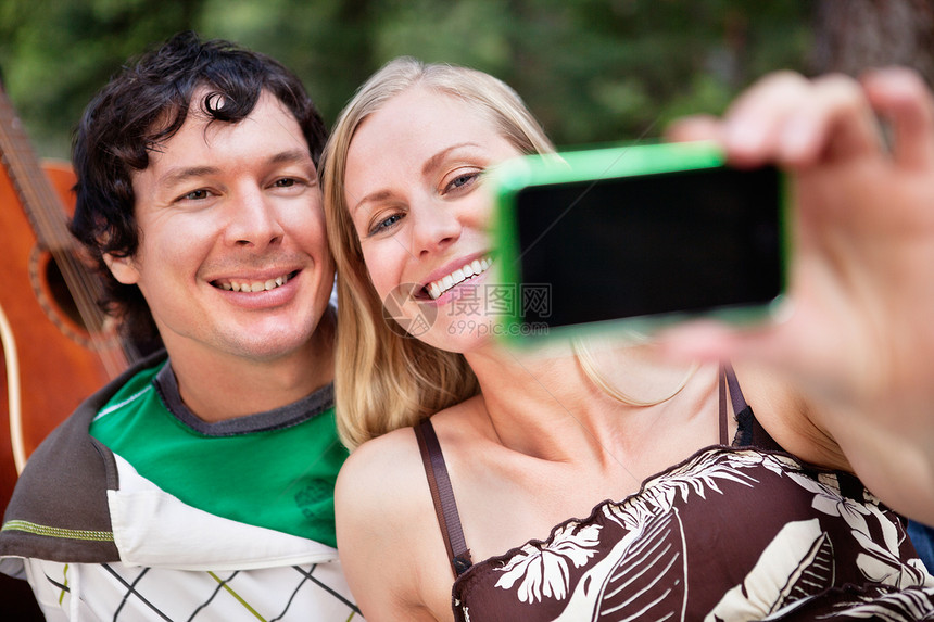 年轻快乐的一对夫妇在拍摄自己图片
