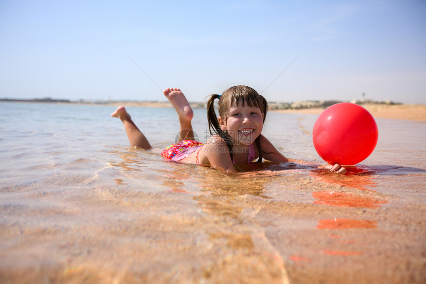 海滩上的女孩飞溅自由微笑快乐冲浪活动热带童年天空假期图片