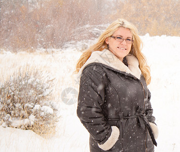 时装妇女金发女郎下雪外套背景图片