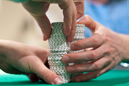 堆叠扑克芯片的手筹码水平游戏毛毡背景图片