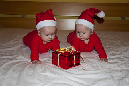 带圣诞礼物和帽子的年轻双胞胎背景图片