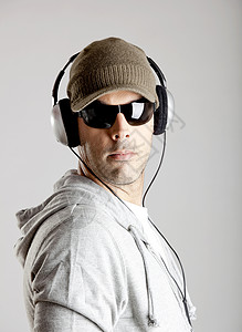 听音乐男人太阳镜青年音乐手机帽子工作室姿势男生耳机背景图片