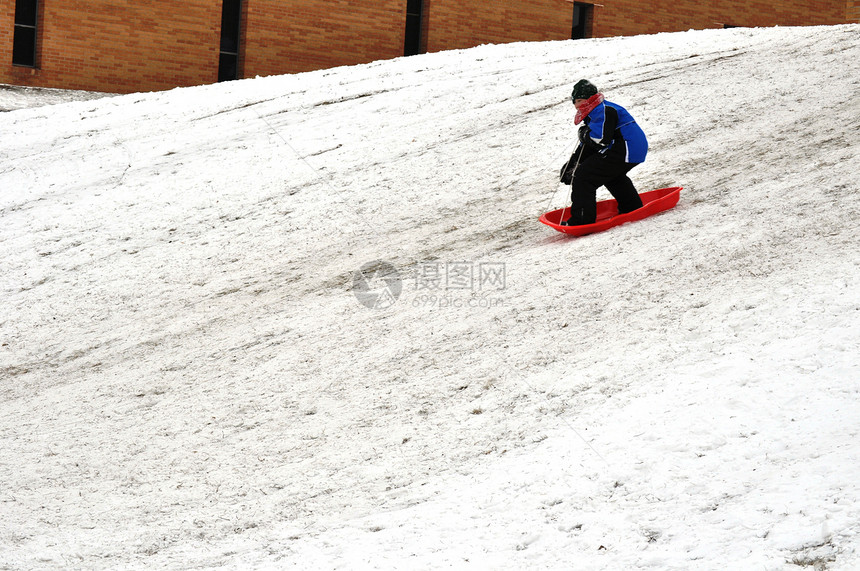 山顶的雪橇滑雪爬坡乐趣运动图片
