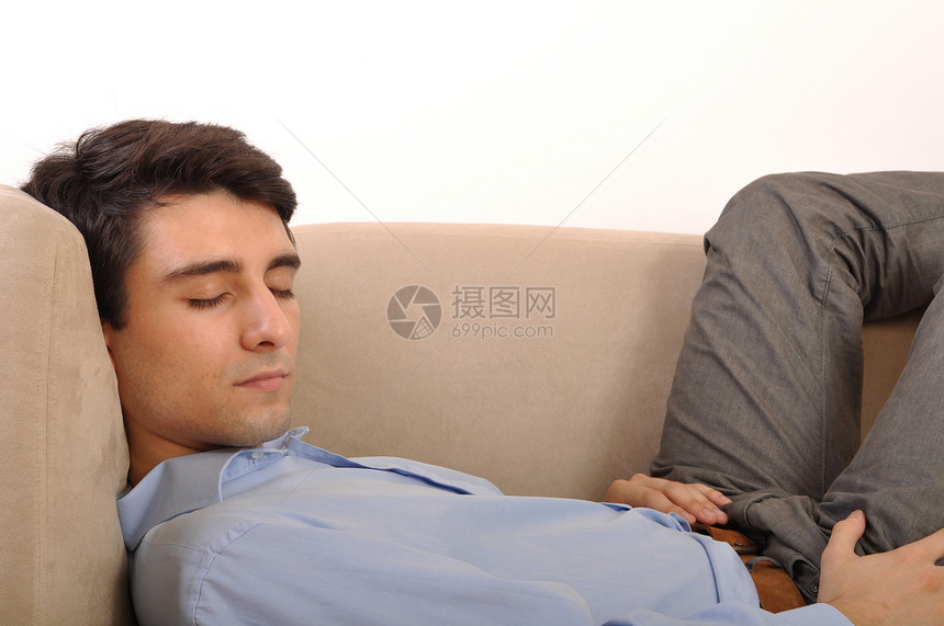 男人睡在沙发上房间长椅成人闲暇衣服白色衬衫男性家具小憩图片