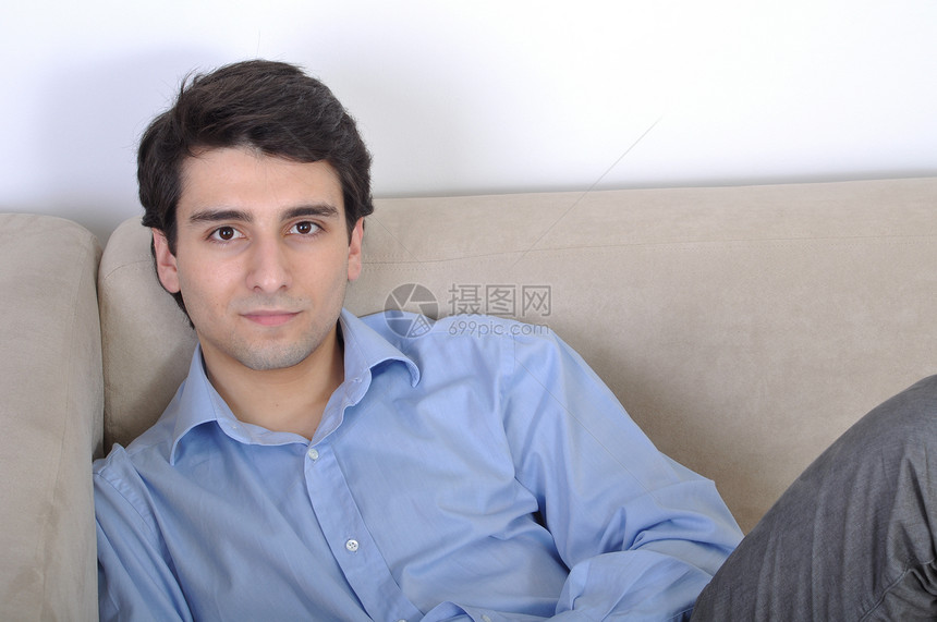 男人在沙发上放松房子闲暇幸福长椅休息衬衫男性蓝色成人生活图片