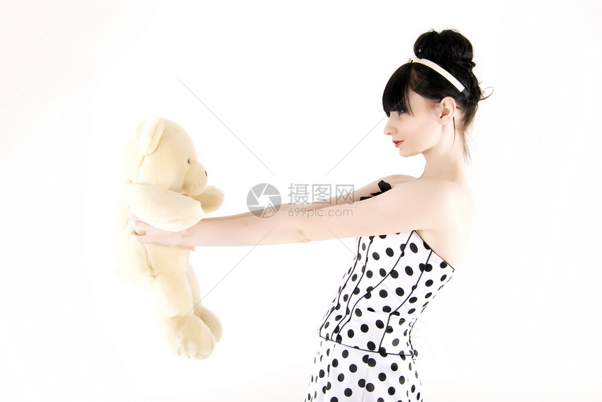带泰迪熊的年轻女子快乐乐趣美丽女孩微笑展示女士钦佩幸福玩具图片