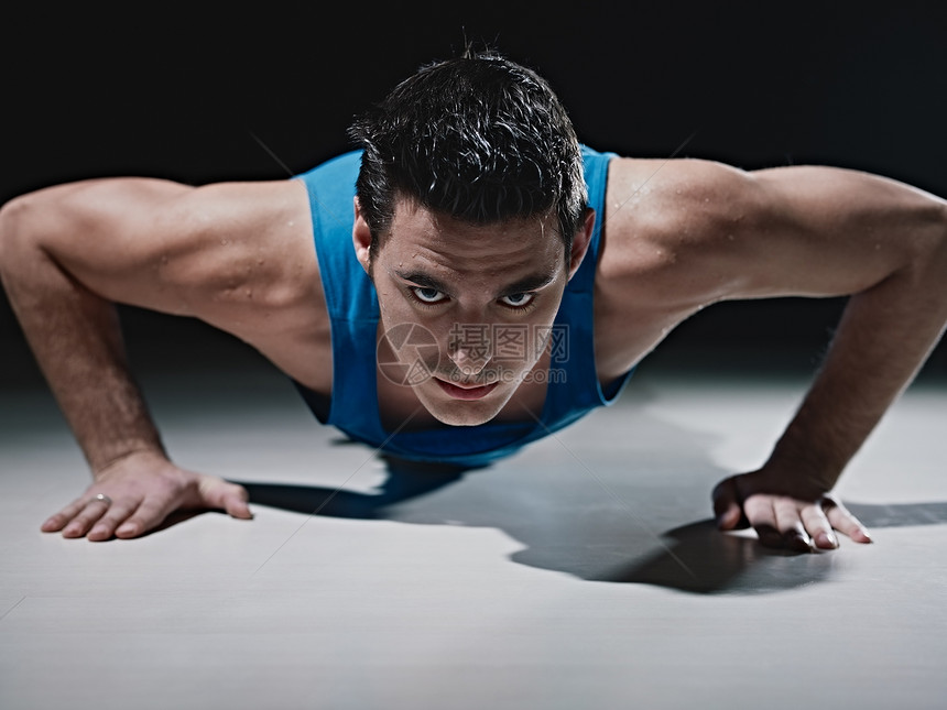 男人在黑人背景下做俯卧撑健身房福利成人肌肉锻炼有氧运动背心白色运动装专注图片