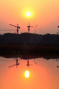 建筑工地远山外滩倒象太阳城市晚霞草图背景图片