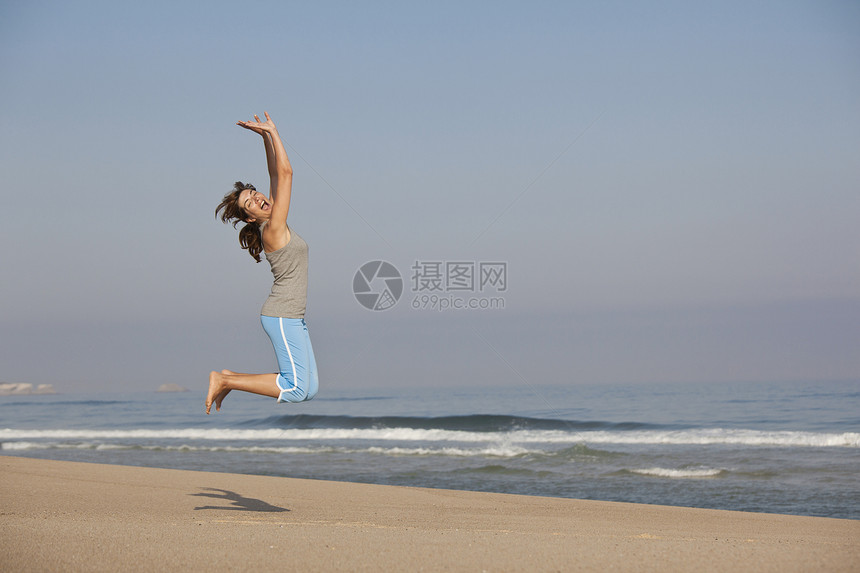 跳跃天空海洋微笑身体自由闲暇海滩女孩幸福旅行图片