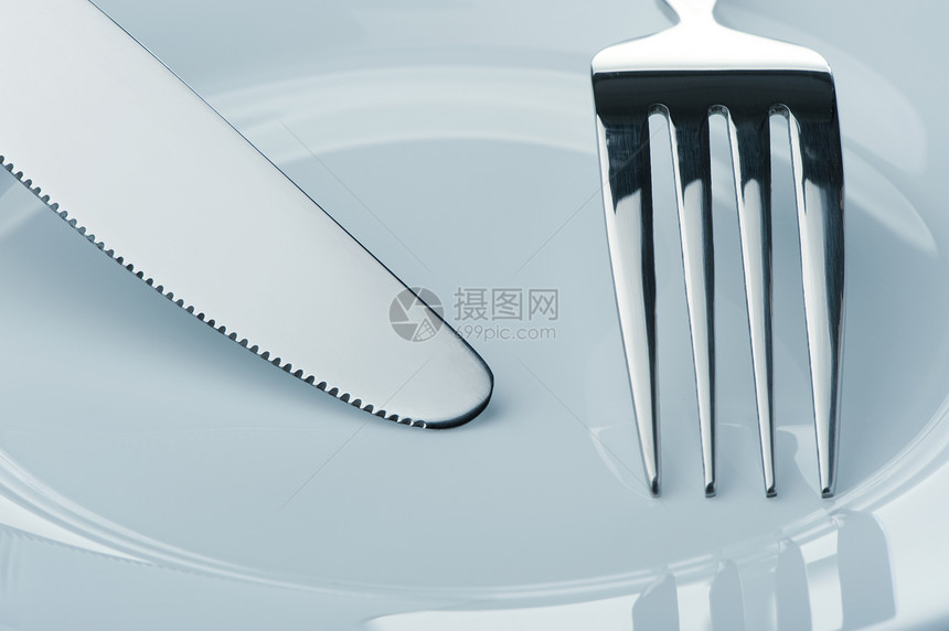 刀和叉在盘子上用具食物厨房刀刃餐具反射桌子阴影蓝色剪裁图片