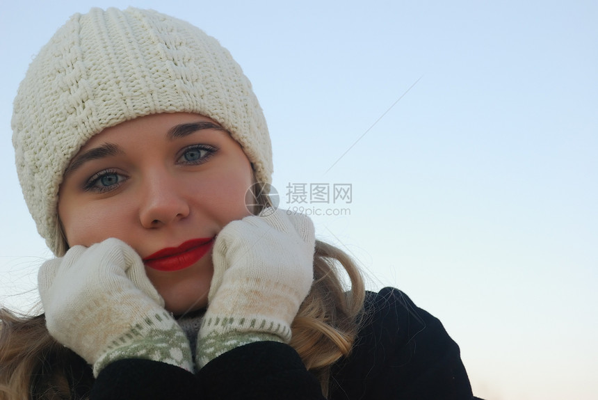 身着冬衣的女孩微笑快乐天空场景喜悦季节幸福蓝色闲暇沉思图片