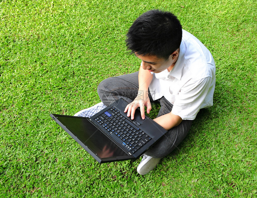 户外使用计算机的亚洲人公园场地技术学生闲暇天空蓝色笔记本教育男性图片