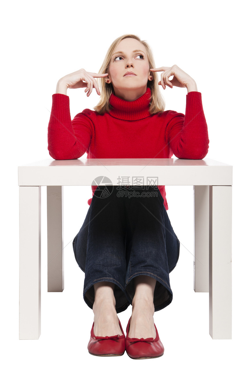 年轻女士坐在有趣的小桌子上工作助手沉思女性学生表情人士套衫白色商务图片