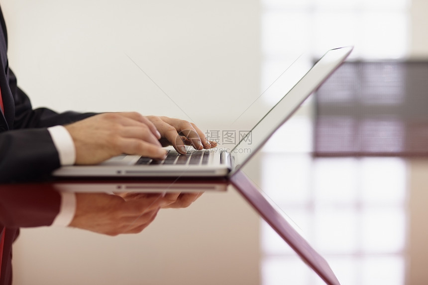 商务人士在笔记本电脑上打字生意人工作互联网中年人会议职场成人男性套装办公室图片