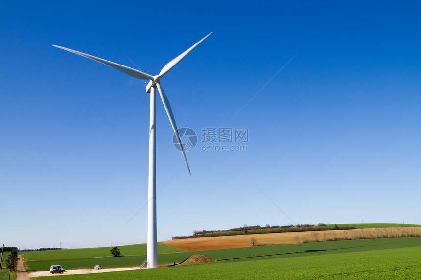 晴蓝天空下风力涡轮机涡轮力量团体技术公园旋转场地奶牛保护风车图片