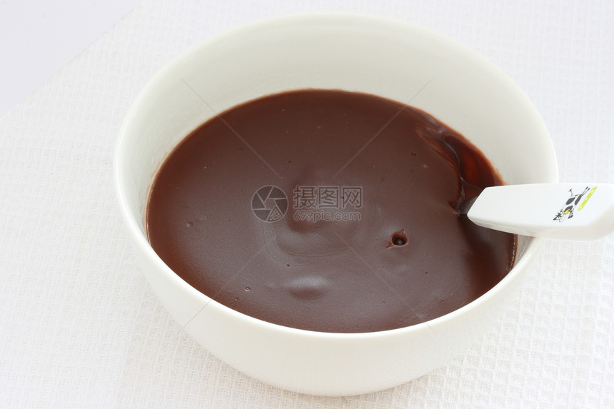 巧克力布丁奶油和果冻在白碗里白色勺子食物图片