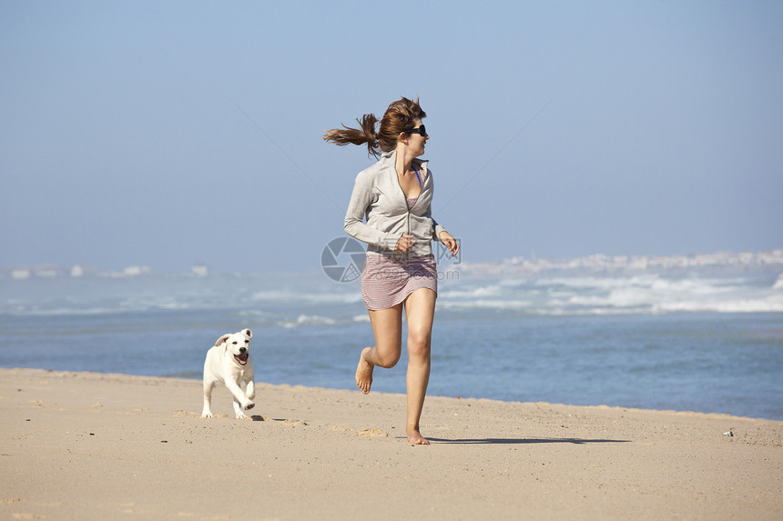 女孩带着可爱的狗幸福猎犬人行道闲暇海岸动物宠物海滩乐趣小狗图片