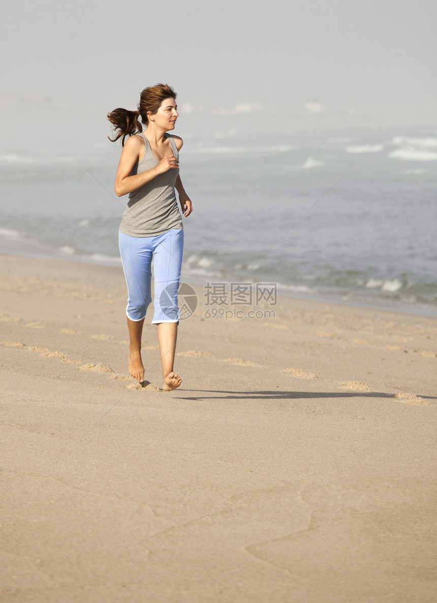 女孩在跑乐趣活动慢跑跑步海洋喜悦女性蓝色训练幸福图片