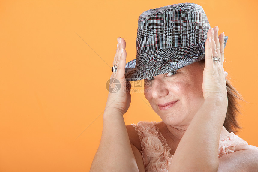 女性握着她的帽子图片