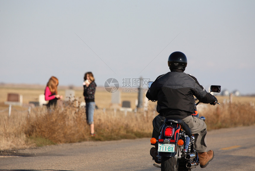 沿萨斯喀彻温公路经过两个女孩的摩托车手图片