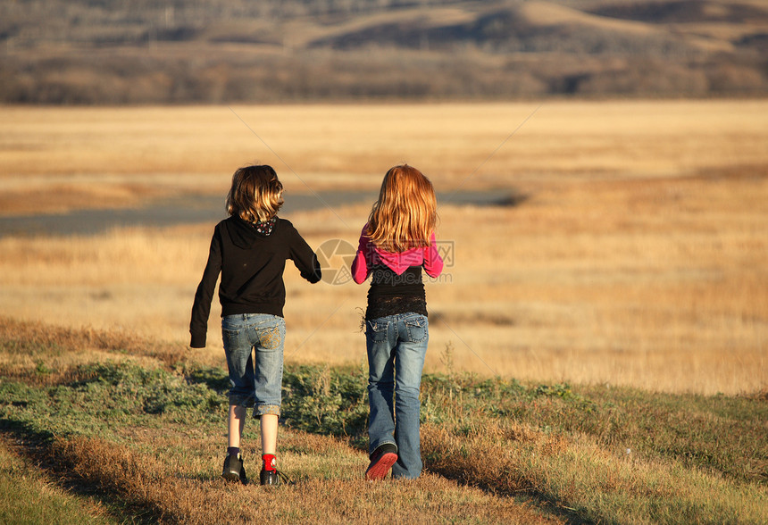 两名女孩在萨斯喀彻温的风景地带沿堤道行走乡村活动孩子们农村水平女孩们避难所图片