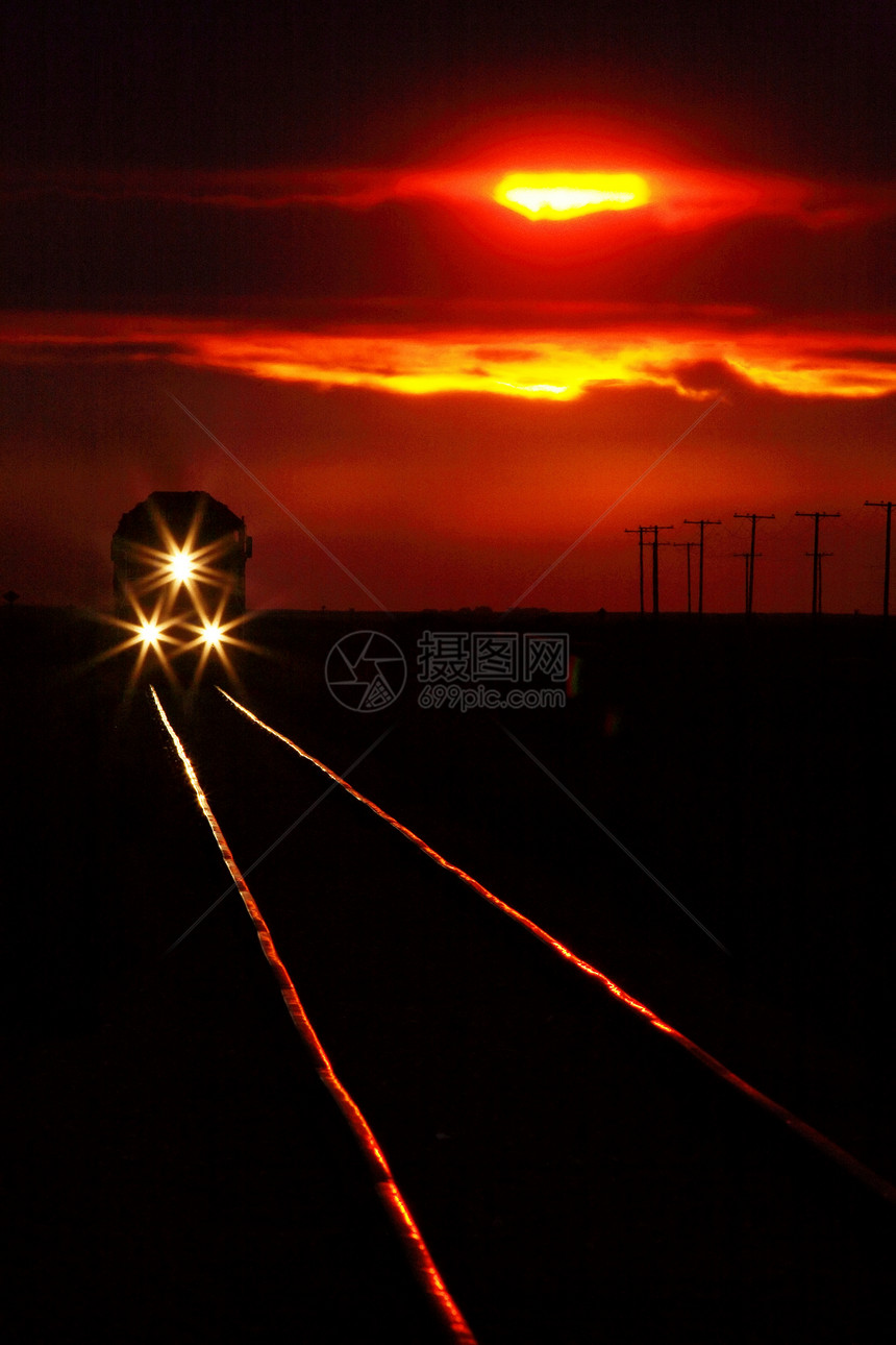 近日落日附近快接近的长程列的景象旅行乡村美术大草原剪影铁路风景曲目火车头灯图片