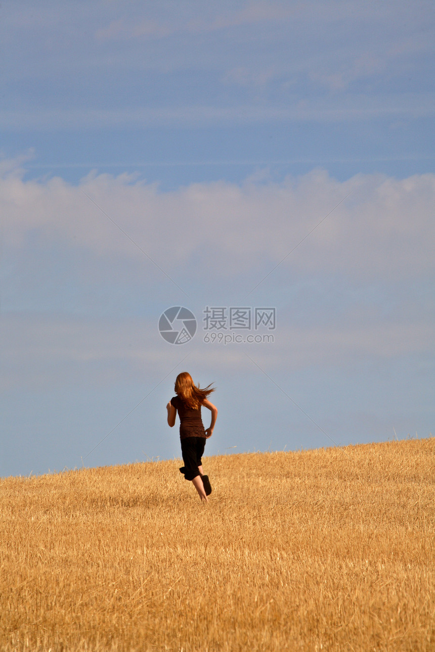 年轻女孩在萨斯喀彻温省一个破碎的田野里奔跑跑步农村场地乡村孩子们活动图片