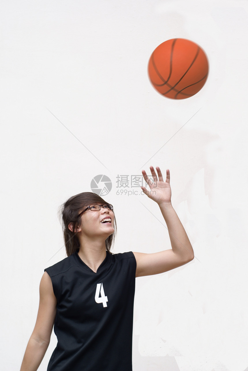 快乐的亚洲女性青少年篮球运动员 看着球图片
