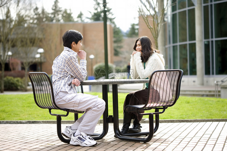 两个年轻青少年坐在户外聊天的年轻人一起坐在一起图片
