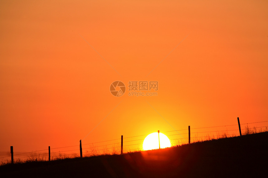萨斯喀彻温山脊围栏后面的太阳落下图片