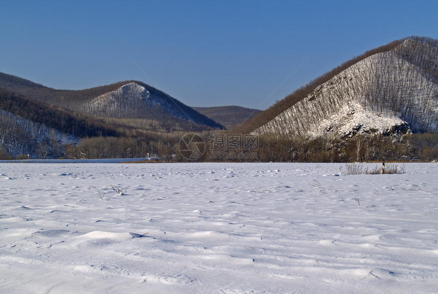 冬季风景阴影场地蓝色白色雪堆木头山坡天空草地图片