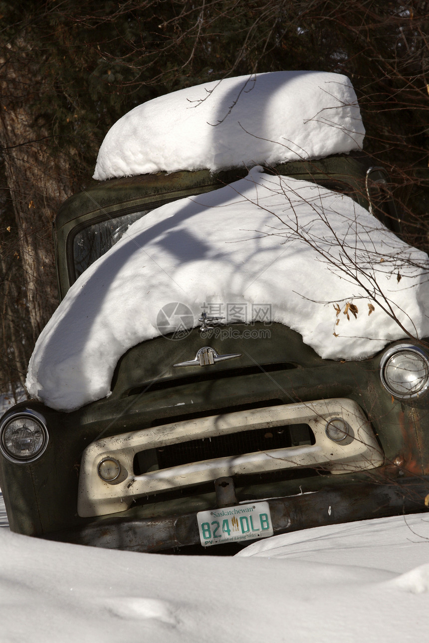 雪雪堆在一辆废弃的旧卡车上图片