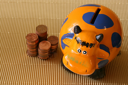 货币堆叠玩具奶牛铜币金子教育硬币橙子背景图片