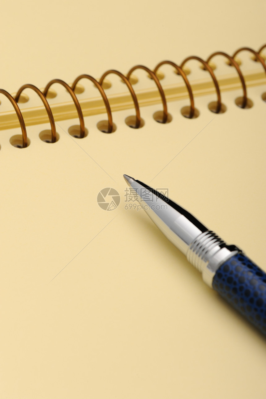 笔和笔记本 在黄纸的螺旋上笔记空白写作办公室日记戒指文档蓝色金属墨水图片