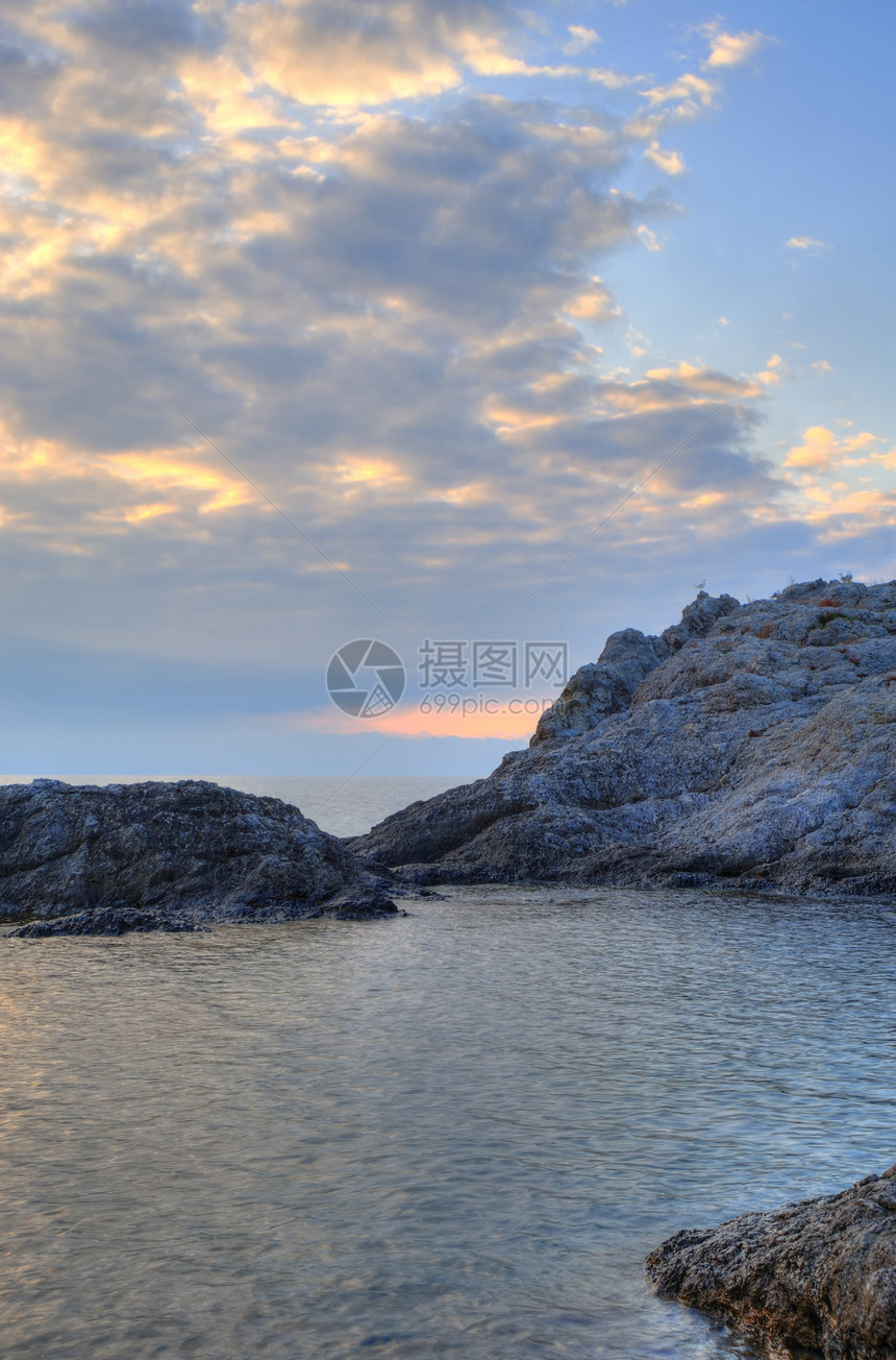 夜间的海岸线和山岳风暴假期卵石日落边缘地平线薄雾天空石头阳光图片