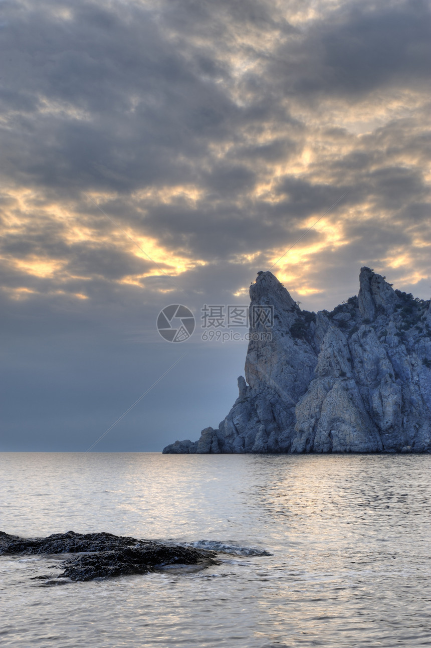 夜间的海岸线和山岳边缘假期巨石阳光岩石风暴场景地平线卵石海景图片