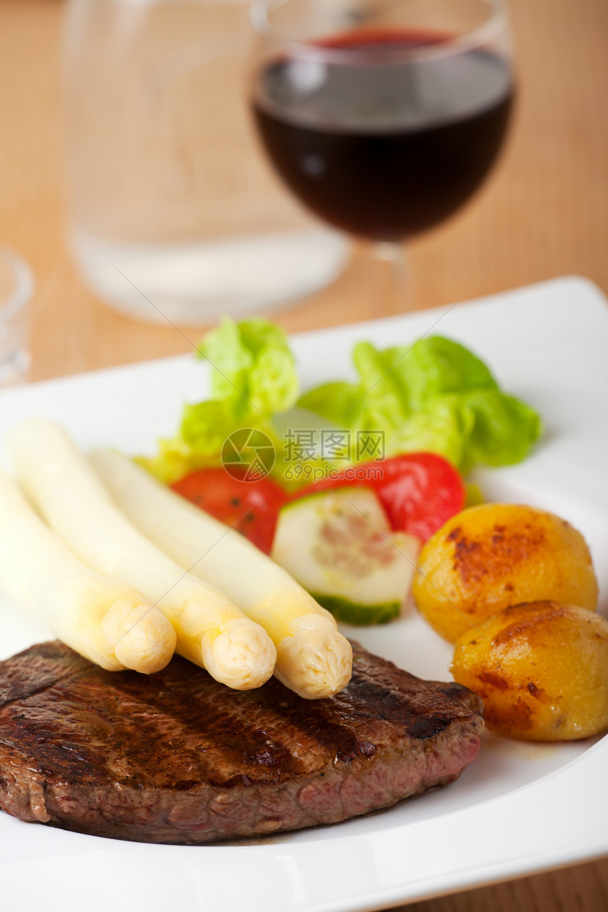 牛排上的白白土豆牛扒食物红色蔬菜沙拉玻璃白色棕色桌子图片
