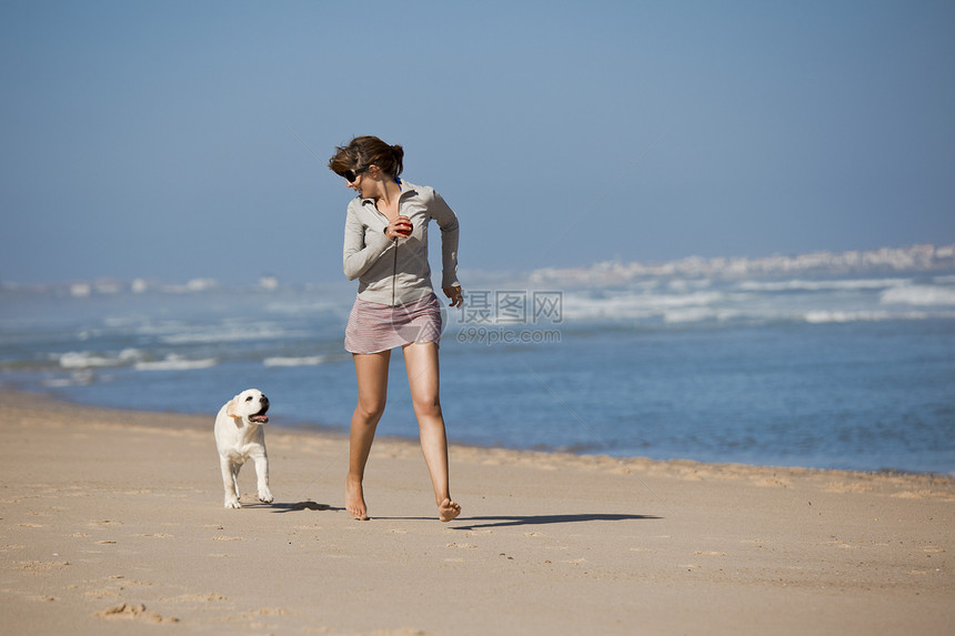 女孩带着可爱的狗人行道喜悦闲暇朋友猎犬跑步友谊乐趣微笑海滩图片