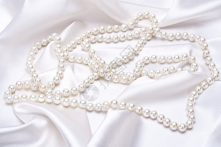 白色珠子白边上的珠宝项链丝绸奢华宏观折叠礼物白色订婚纺织品宝石背景